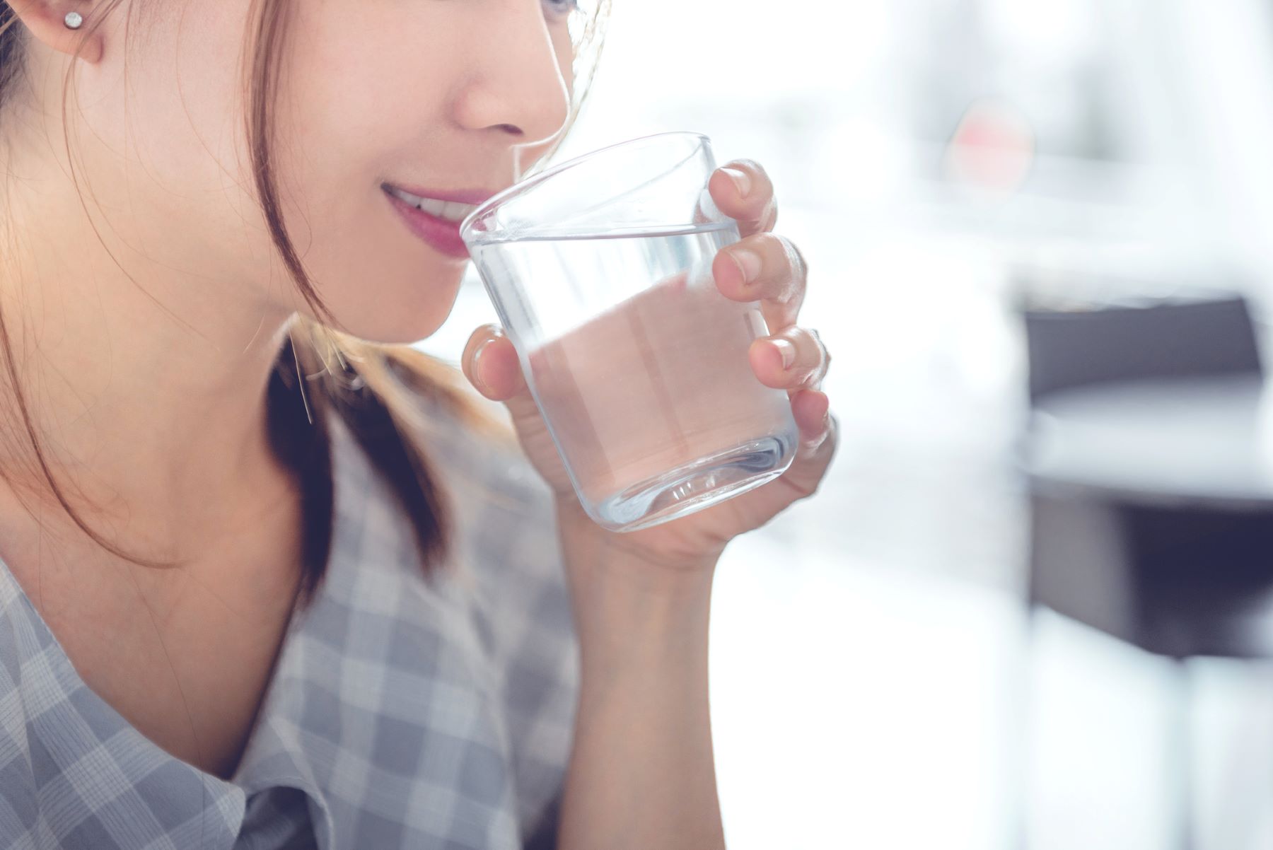 コップの水を飲もうとしている女性