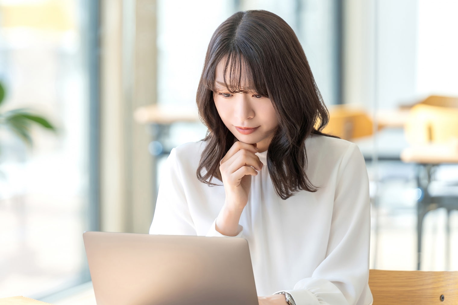 PCを見つめて悩んでいる女性