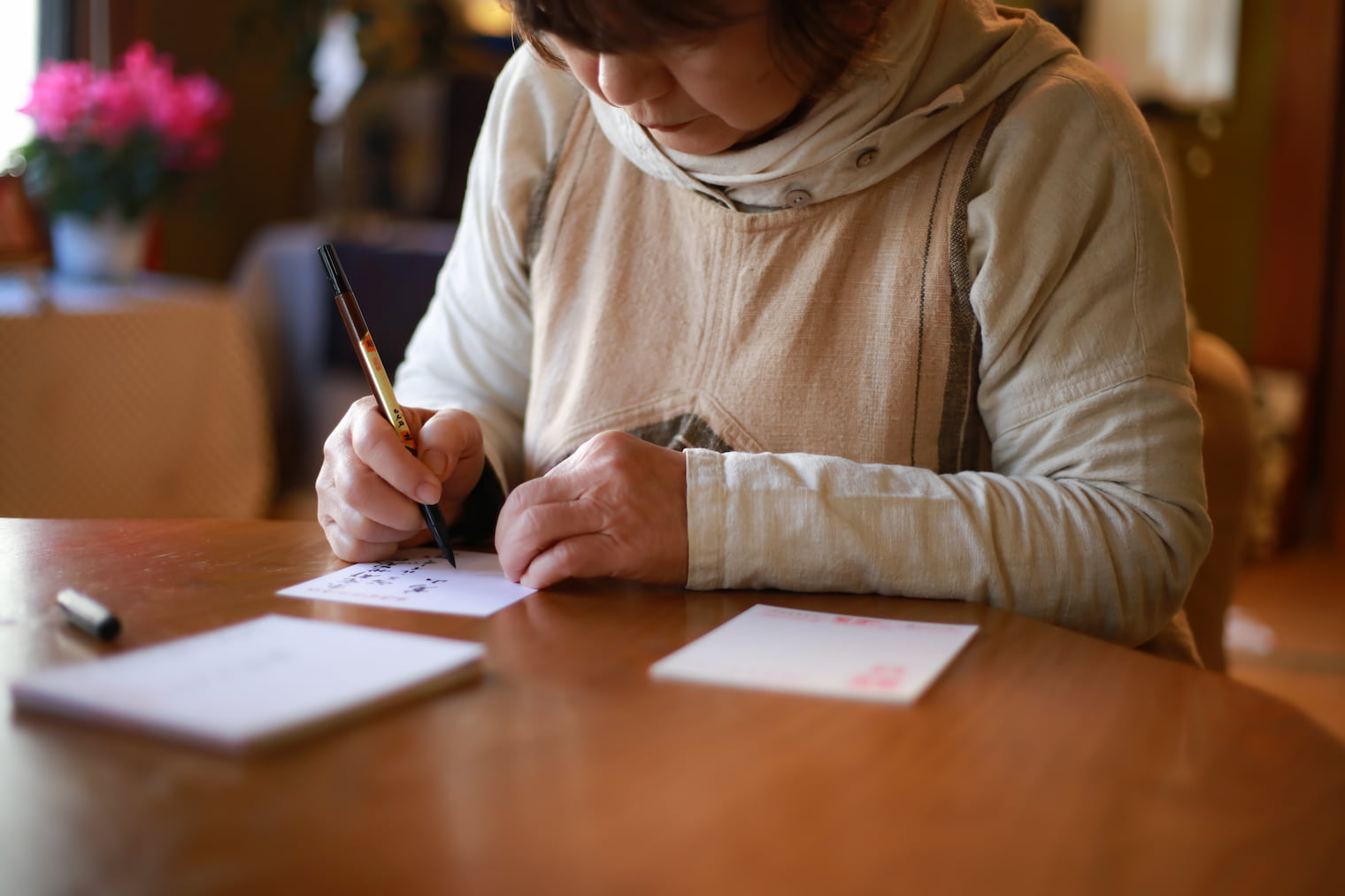 年賀状を書いている高齢の女性