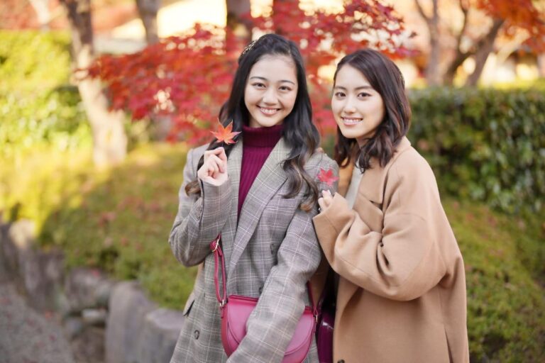 紅葉を背景にコートを着た女性2人
