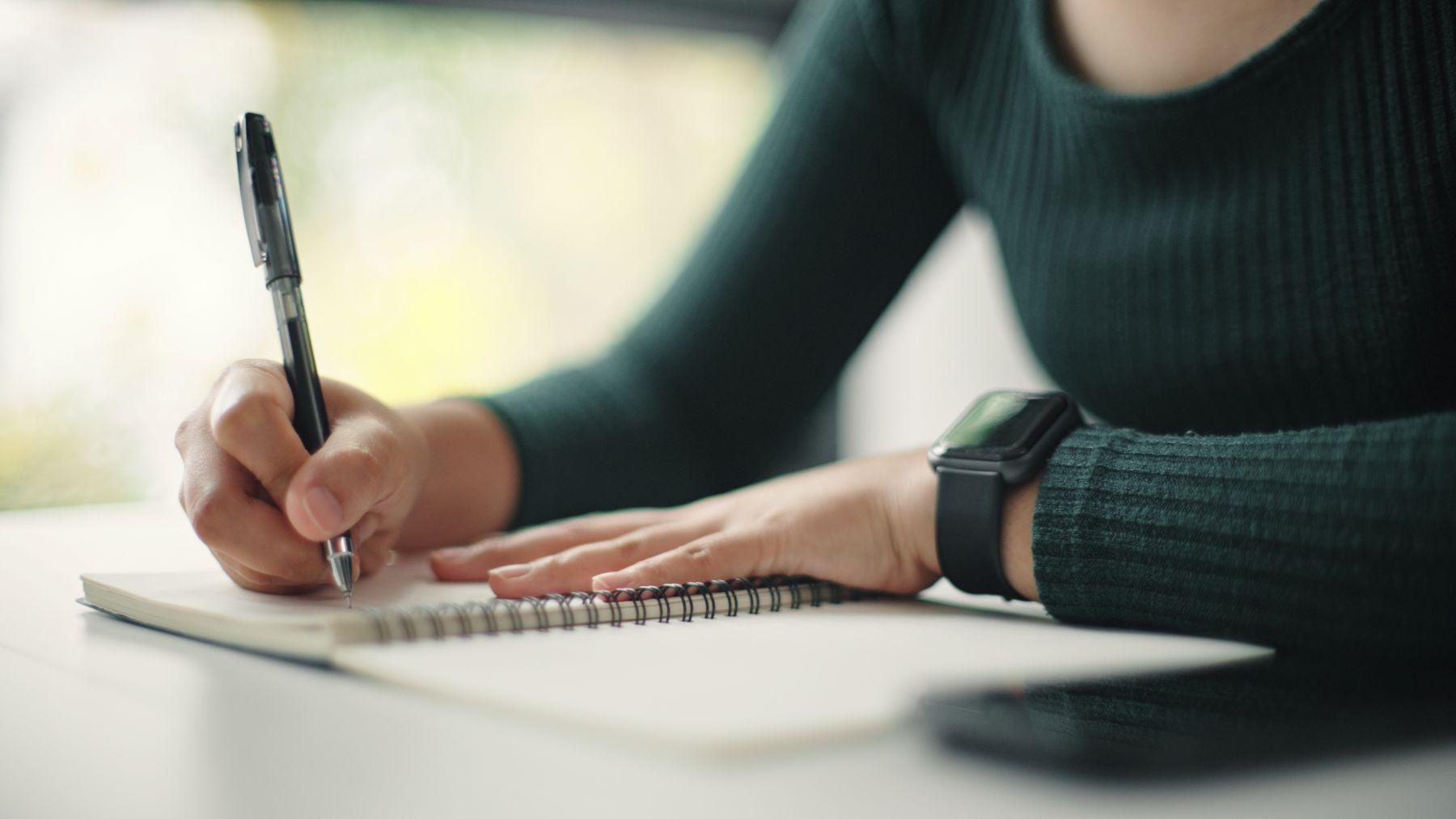 ノートに文章を書く女性のイメージ