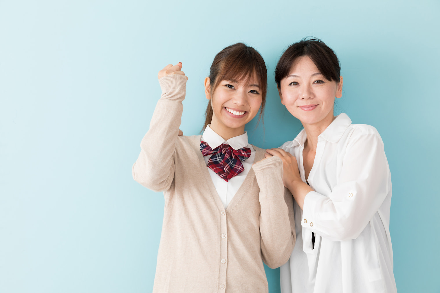 ガッツポーズをする女子高生と母親