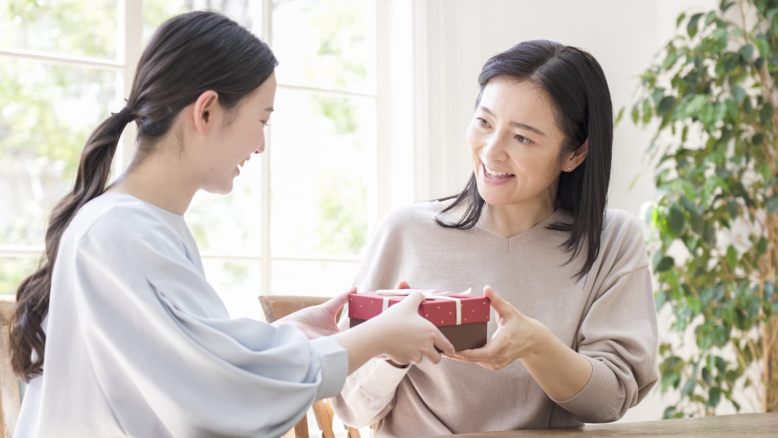 母の日に母親にプレゼントを渡す娘