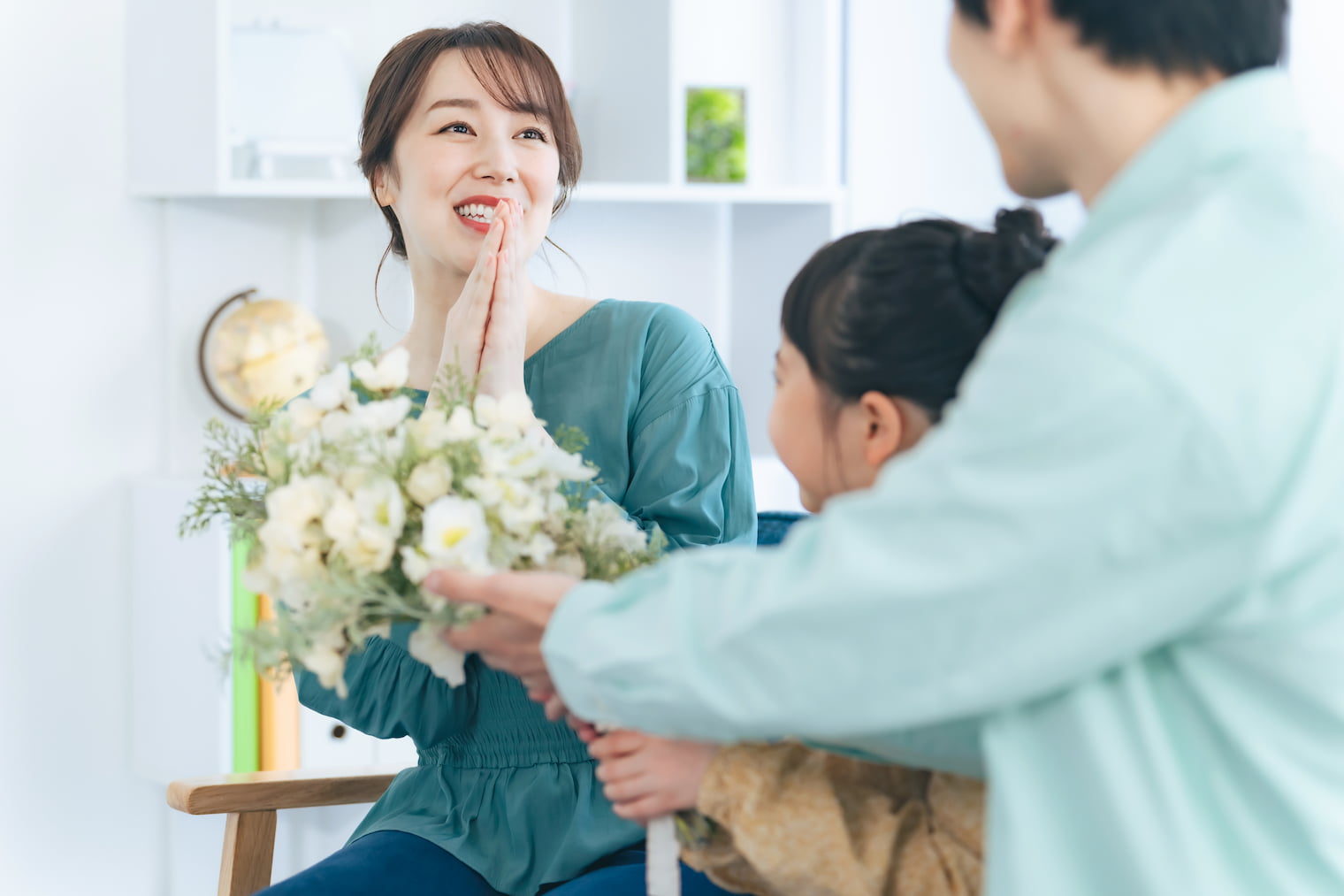 母親に花束をプレゼントする父と娘