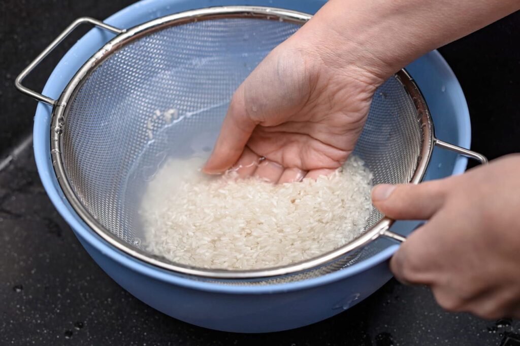 ザルで米を研ぐ手元